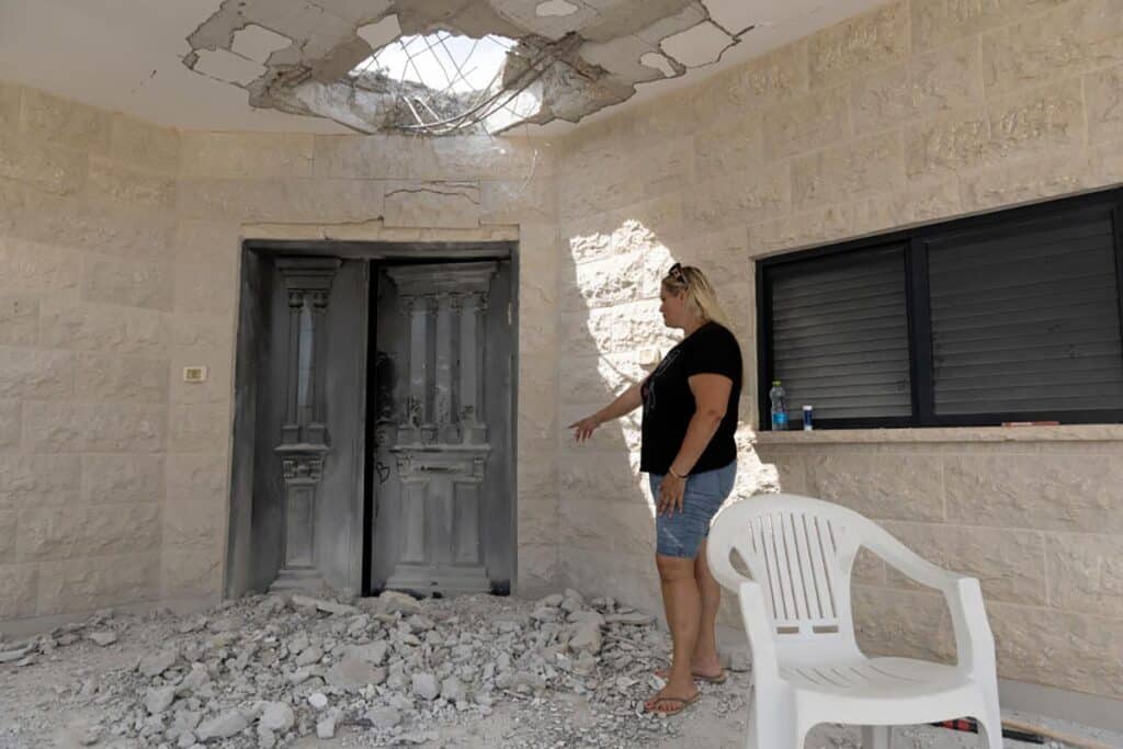 A woman inspects a house that was damaged by a rocket fired from Lebanon on August 25, 2024 in Manot, Israel.