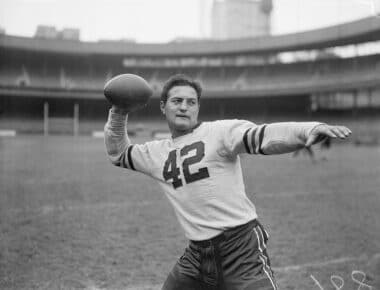 New York, New York: Sid Luckman, a local boy who made good with the grid warriors of Columbia University, shows off the passing technique that won him honors and a place with the Chicago Bears professional football team. He was photographed today during a workout of the Bears at the New York Polo Grounds, where the Bears will clash with the New York Giants on Sunday.