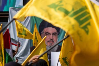 Iranian worshippers wave Lebanon's Hezbollah flags in front of a portrait of the Hezbollah Secretary General, Hassan Nasrallah, during an anti-Israeli protest to condemn Israel's strike on Nasrallah, after Friday prayers ceremonies in downtown Tehran, Iran, on September 27, 2024.