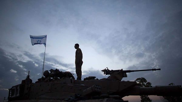 An Israeli soldier stands on his tank in a deployment area on November 22, 2012 on Israel's border with the Gaza Strip. (Photo by Uriel Sinai/Getty Images)