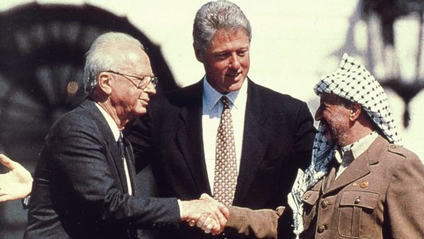 American President Bill Clinton watches as the Israeli Prime Minister Yitzhak Rabin (1922 - 1995) shakes hands with the Palestinian leader Yasser Arafat in the garden of the White House after the signing of the deal transferring much of the West Bank to Palestinian control.   (Photo by MPI/Getty Images)